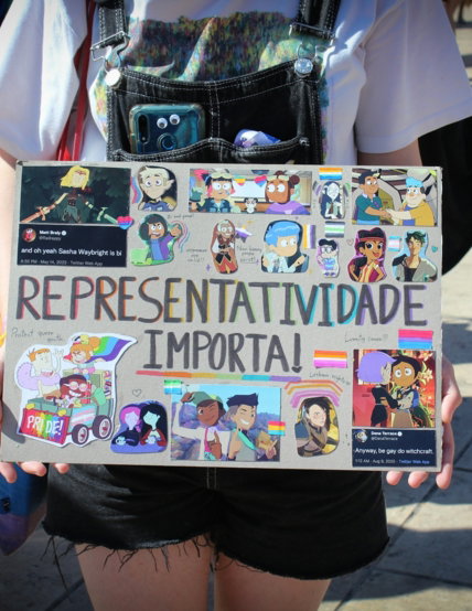 a person holding a sign with a bunch of stickers on it